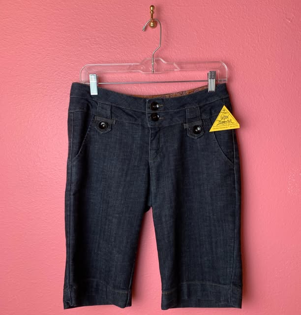 Vintage denim shorts on a pink wall